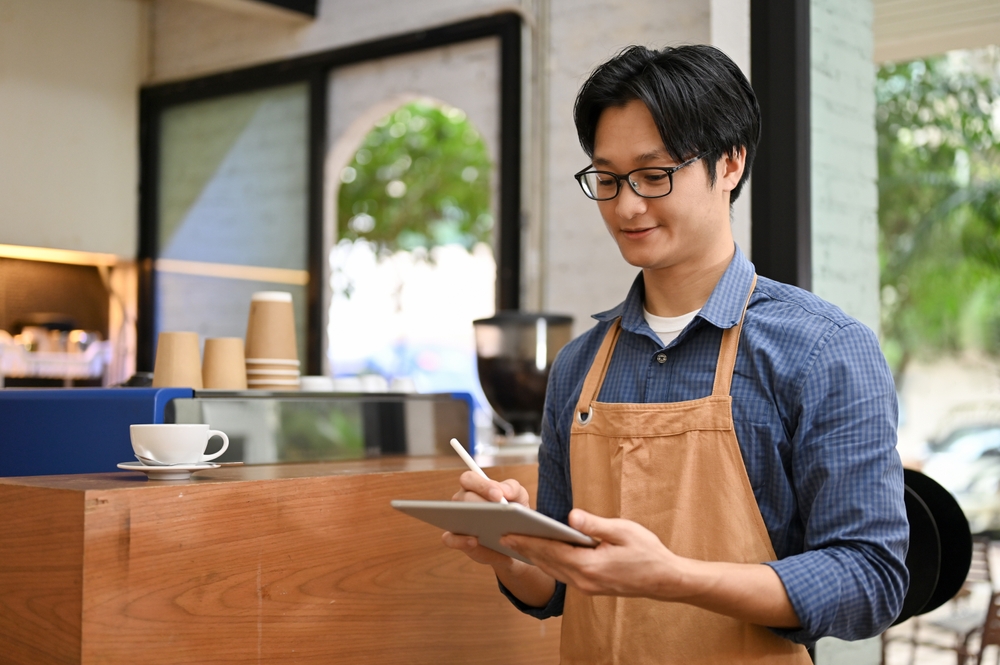 a franchise owner scribbling on a tablet
